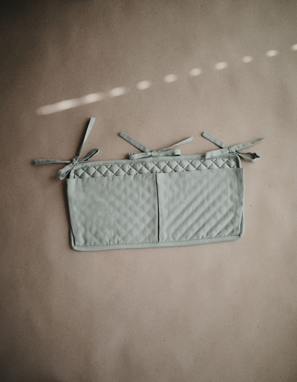 Mushie lovytės kišenė „Crib Pocket“ – Roman Green