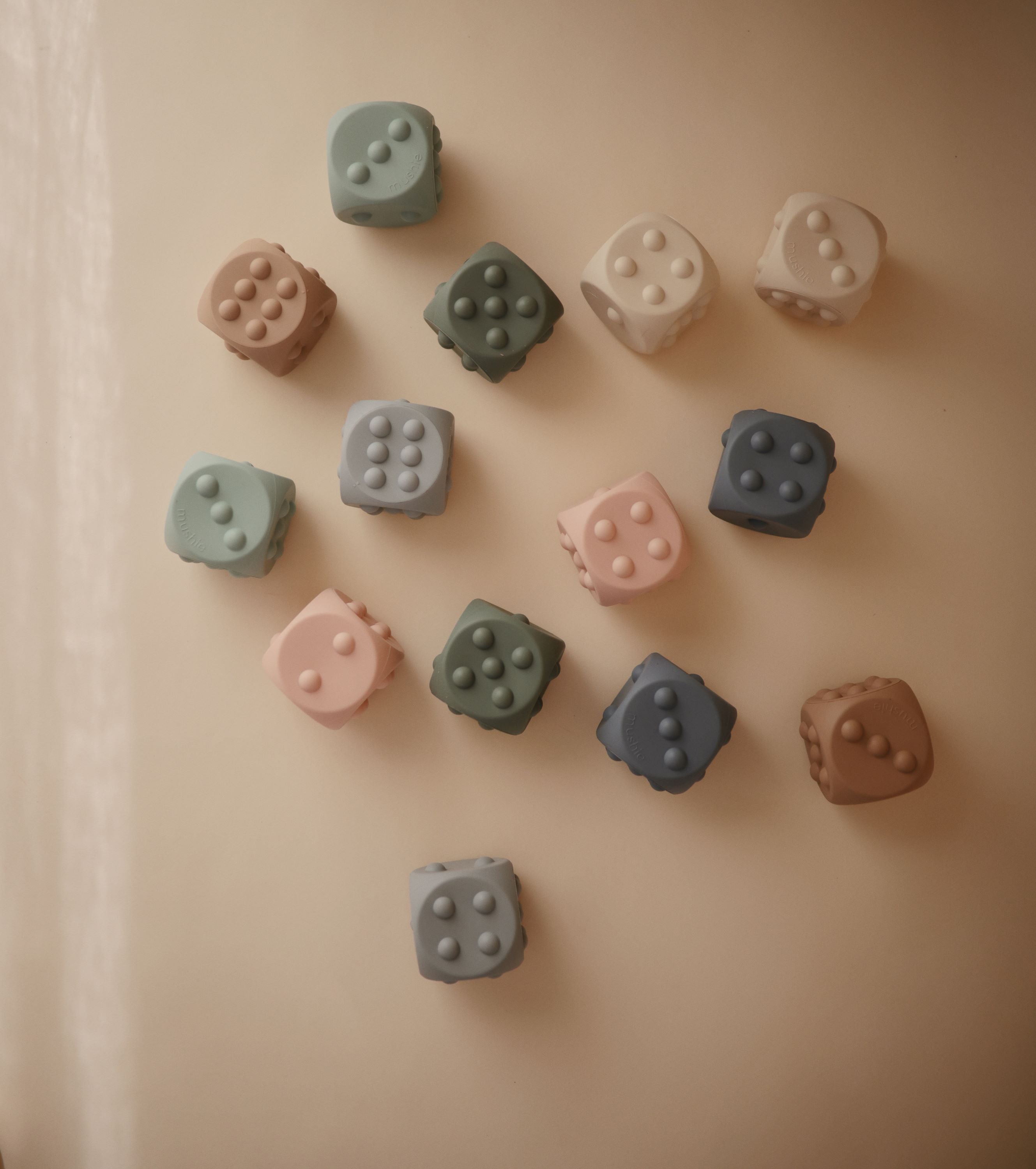 Mushie spaudžiamas žaislas „Dice Press Toy“, 2 vnt. – Cambridge Blue/Shifting Sands